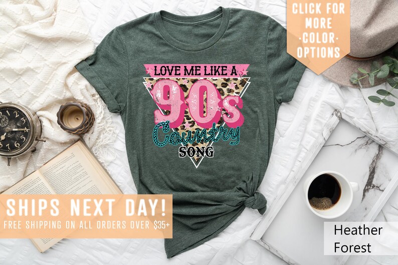 May include: Green t-shirt with a pink triangle graphic that says "Love Me Like A 90's Country Song" with a leopard print background.