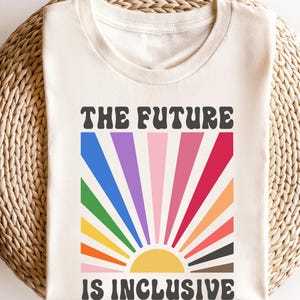 May include: A white t-shirt with a rainbow sunburst graphic and the text "THE FUTURE IS INCLUSIVE".