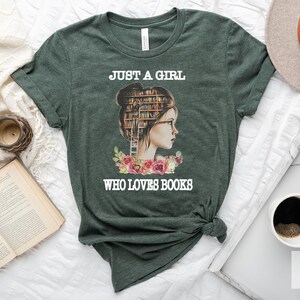 Pu&ograve; includere: Una maglietta verde con il testo "Just a girl who loves books" e un'immagine di una donna con libri impilati sulla testa.