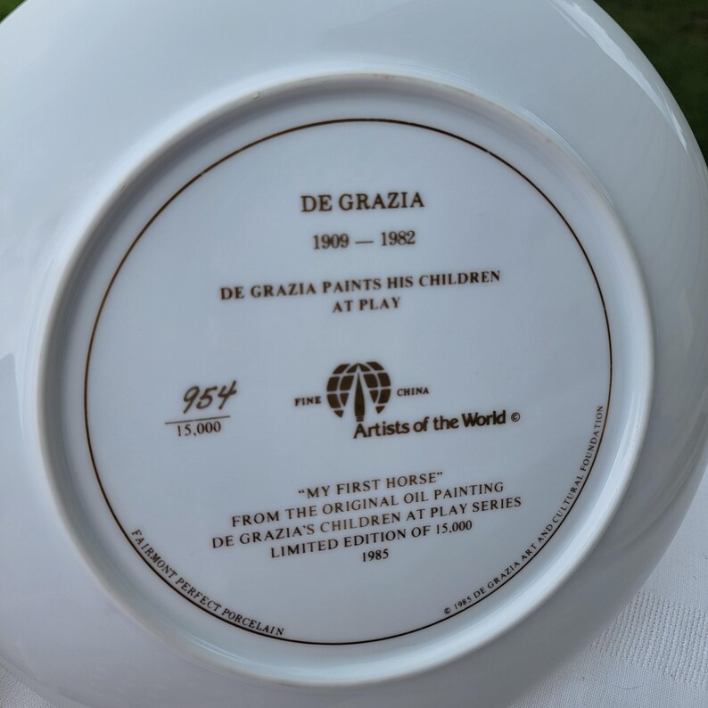K&ouml;nnte beinhalten: Ein wei&szlig;er Porzellanteller mit braunem Rand und Text. Der Teller zeigt den Text "DE GRAZIA" und "MY FIRST HORSE" aus dem Original-&Ouml;lgem&auml;lde. Es ist eine limitierte Auflage von 15.000 St&uuml;ck aus dem Jahr 1985.