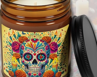 May include: Two amber glass soy candles with a Day of the Dead sugar skull design. The larger candle is 9 ounces and the smaller candle is 4 ounces. The candles are available in a variety of scents, including unscented, Atlantis Whisper, Christmas Warmth, White Sage + Lavender, Peppered Passionfruit, Coconut Cream + Cardamom, and Cinnamon Vanilla.