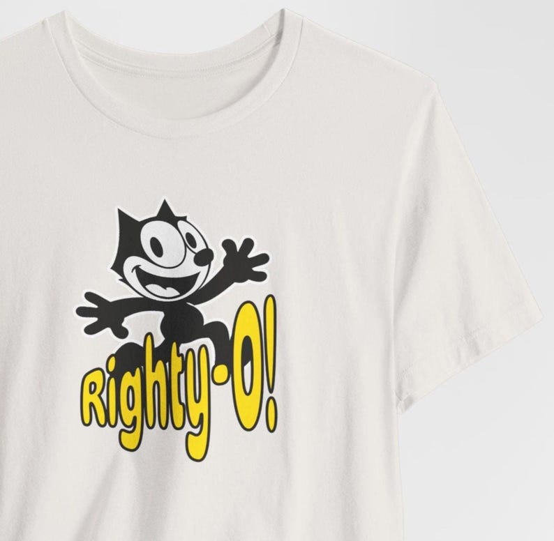 May include: White t-shirt with a black and white cartoon cat graphic and the text "Righty-O!" in yellow.