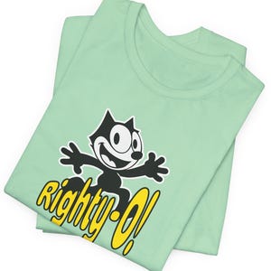 May include: A mint green t-shirt with a black and white cartoon cat wearing a yellow collar and the text "Righty-O!" in yellow.