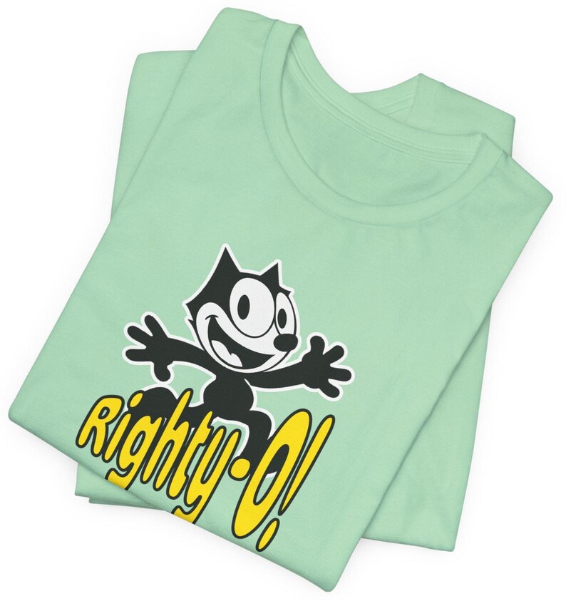 May include: A mint green t-shirt with a black and white cartoon cat wearing a yellow collar and the text "Righty-O!" in yellow.