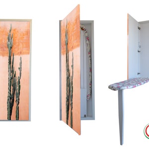 Op de afbeelding: Een wit, opvouwbaar strijkplank met een bloemenprint is bevestigd aan een kast met een cactusprintdeur. De kast is in de eerste afbeelding gesloten, in de tweede afbeelding open en de strijkplank is in de derde afbeelding neergeklapt. De kast heeft een wit frame en een label met de tekst "Made in Italy".