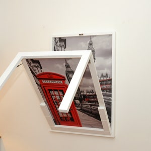 Könnte beinhalten: Ein weißer Klapptisch mit einem Londoner Stadtbild-Druck. Der Tisch ist zusammengeklappt und an einer Wand befestigt. Der Druck zeigt eine rote Telefonzelle, einen Doppeldeckerbus und Big Ben.