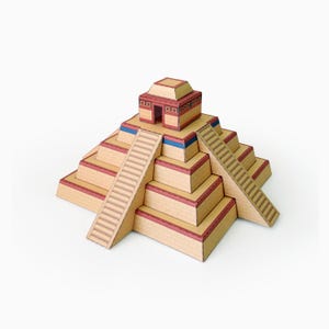 Peut inclure: Un modèle en papier de pyramide à degrés avec un motif de briques beige, des bordures rouges et des accents bleus. La structure comprend un escalier central menant à un petit temple au sommet avec une entrée carrée et un toit plat.