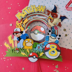 May include: A colourful Pokemon themed cake topper with the name "Matthew" and the number "8" on it. The topper features characters from the Pokemon franchise, including Pikachu, Squirtle, Bulbasaur, and Charizard.