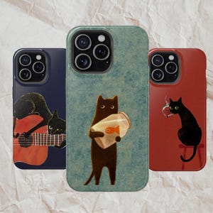 May include: Three phone cases with cat illustrations. One case is navy blue with a black cat playing a guitar. Another is teal with a cat holding a fishbowl. The third is red with a cat on a stool.