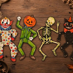 Peut inclure: Quatre figurines articulées en papier avec des attaches métalliques aux articulations : un clown à pois, un personnage à tête de citrouille en costume vert, un squelette beige et un chat noir portant un chapeau et un nœud papillon orange.