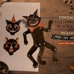 May include: A black cat paper doll with articulated limbs connected by silver fasteners, featuring an orange bow tie. The image includes two additional cat head illustrations, one wearing an orange hat, and text reading VINTAGE HALLOWEEN BLACK CAT JOINED PAPER DOLL PICKLES PRINT CUT ASSEMBLE INSTANT DIGITAL DOWNLOAD.