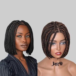May include: Two braided bob wigs, one black and one brown, with a lace front. The wigs are styled in a short bob with small braids. The wigs are on mannequins with neutral makeup. The text "Jara Hair" is visible in the bottom right corner of the image.