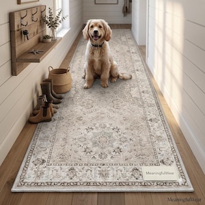 May include: A long rectangular runner rug featuring a faded beige and grey traditional floral pattern with a decorative border. The rug has a small rectangular label in the bottom right corner with the text MeaningfulWear printed on it.