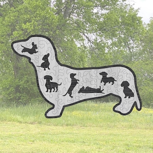 Könnte beinhalten: Ein Holzpuzzle in Form eines Dackels mit einer Silhouette mehrerer Dackel innerhalb der Umrisse.