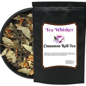 May include: A black resealable pouch with a white label that reads "Tea Whisker Cinnamon Roll Tea". The label also includes a list of ingredients and contact information for the company. The pouch contains loose leaf tea.