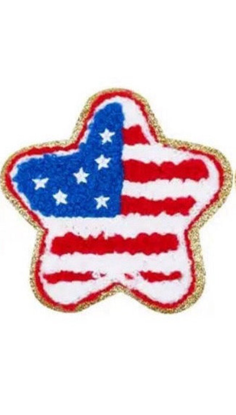 May include: A star-shaped patch featuring the American flag design. The patch has a gold glitter border, a blue field with white stars, and red and white stripes, representing the United States of America.