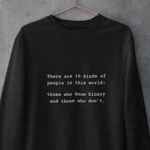 May include: Black sweatshirt with white text that reads "There are 10 kinds of people in this world: those who know binary and those who don't."