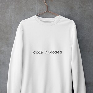 May include: White sweatshirt with the text "code blooded" printed in black on the front.