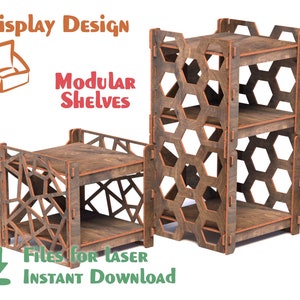 May include: Two wooden shelves with geometric designs. The shelves are made of plywood and have a brown stain. The shelves are modular and can be stacked to create different configurations. The text "Display Design" and "Modular Shelves" is visible in the image.