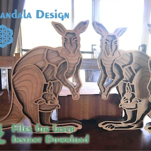 Puede incluir: Tres esculturas de canguro de madera cortadas con láser, cada una con un joey en su bolsa. Las esculturas están intrincadamente detalladas y tienen un efecto de capas. El texto "Archivos para láser Descarga instantánea" es visible en la parte inferior de la imagen.