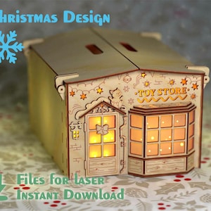 May include: A wooden toy shop building with a lit window and a sign that says "Toy Store". The building is decorated with stars and a cat. This is a laser cut design for a Christmas craft project.