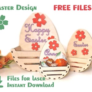 May include: Three wooden Easter egg-shaped boxes with cutouts for candy. The largest box says "Happy Easter" in purple lettering with red flowers. The middle box says "Anna" in purple lettering with red flowers. The smallest box says "Easter" in purple lettering with red flowers.