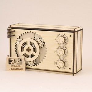 Op de afbeelding: Een houten puzzelbox met een combinatieslotontwerp. De doos heeft zichtbare tandwielen en drie genummerde wijzerplaten. Een klein houten bordje met de tekst "wood-toolbox" staat voor de doos.
