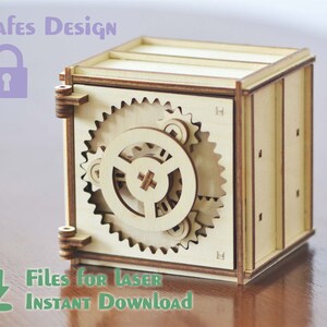 以下が含まれることがあります： ドアから見える詳細な歯車機構を持つ木製金庫のモデル。金庫は薄い茶色の木でできており、小さな金属製の蝶番が付いています。画像の上部に「Safes Design」というテキストが表示されています。