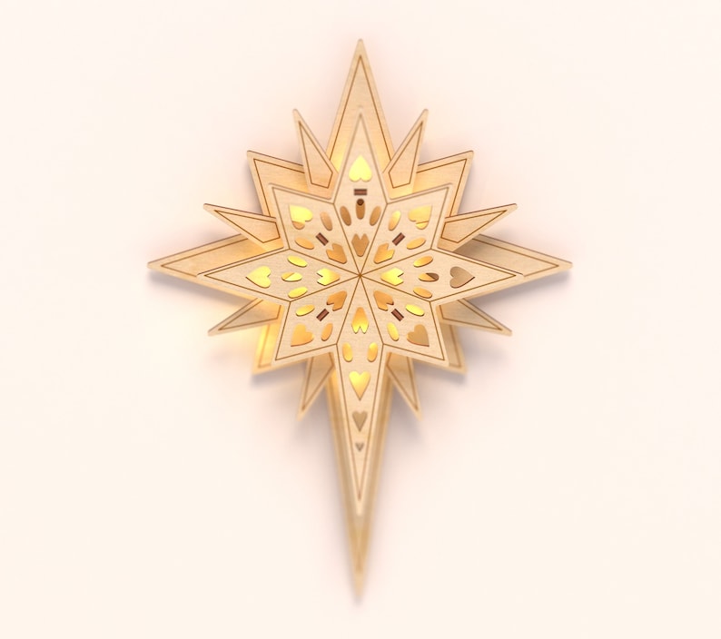 May include: A wooden star-shaped Christmas tree topper with a light brown finish and intricate cutouts in the shape of hearts. The star is illuminated from within, creating a warm glow.