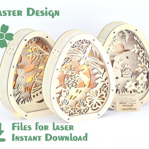 May include: Three wooden Easter egg-shaped light-up decorations with intricate laser cut designs featuring bunnies, flowers, and a moon. The text "wood-toolbox" is visible on a small wooden sign.