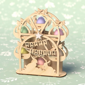 May include: Wooden Easter egg holder shaped like a Ferris wheel with bunnies at the bottom. The holder has six compartments for eggs and a banner that reads "Happy Easter".