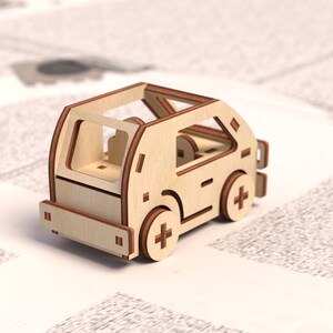 K&ouml;nnte beinhalten: Ein h&ouml;lzernes Spielzeugauto mit hellbrauner Oberfl&auml;che. Das Auto hat einen detaillierten Innenraum und ein schlichtes Design.
