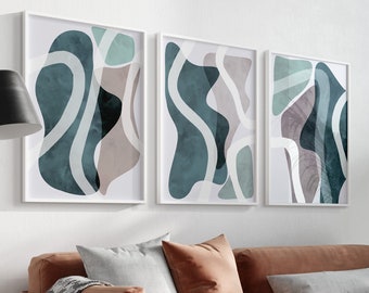 May include: A brown velvet sofa with three pillows and a throw blanket, a wicker chair, and three abstract art prints in white frames with blue and green shapes on a white background. A potted plant is in the corner of the room.