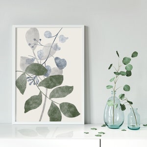 K&ouml;nnte beinhalten: Ein gerahmter Aquarelldruck einer botanischen Illustration mit gr&uuml;nen und blauen Bl&auml;ttern auf cremefarbenem Hintergrund.