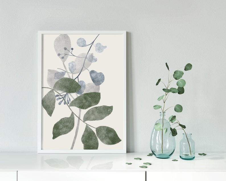 K&ouml;nnte beinhalten: Ein gerahmter Aquarelldruck einer botanischen Illustration mit gr&uuml;nen und blauen Bl&auml;ttern auf cremefarbenem Hintergrund.