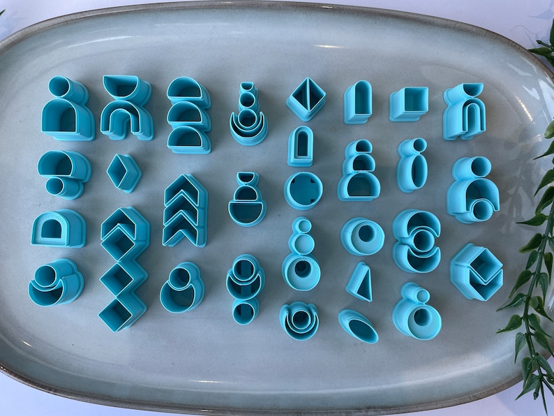 Puede incluir: Un conjunto de 30 cortadores de galletas de pl&aacute;stico azul en varias formas geom&eacute;tricas, incluyendo c&iacute;rculos, cuadrados, tri&aacute;ngulos y arcos.