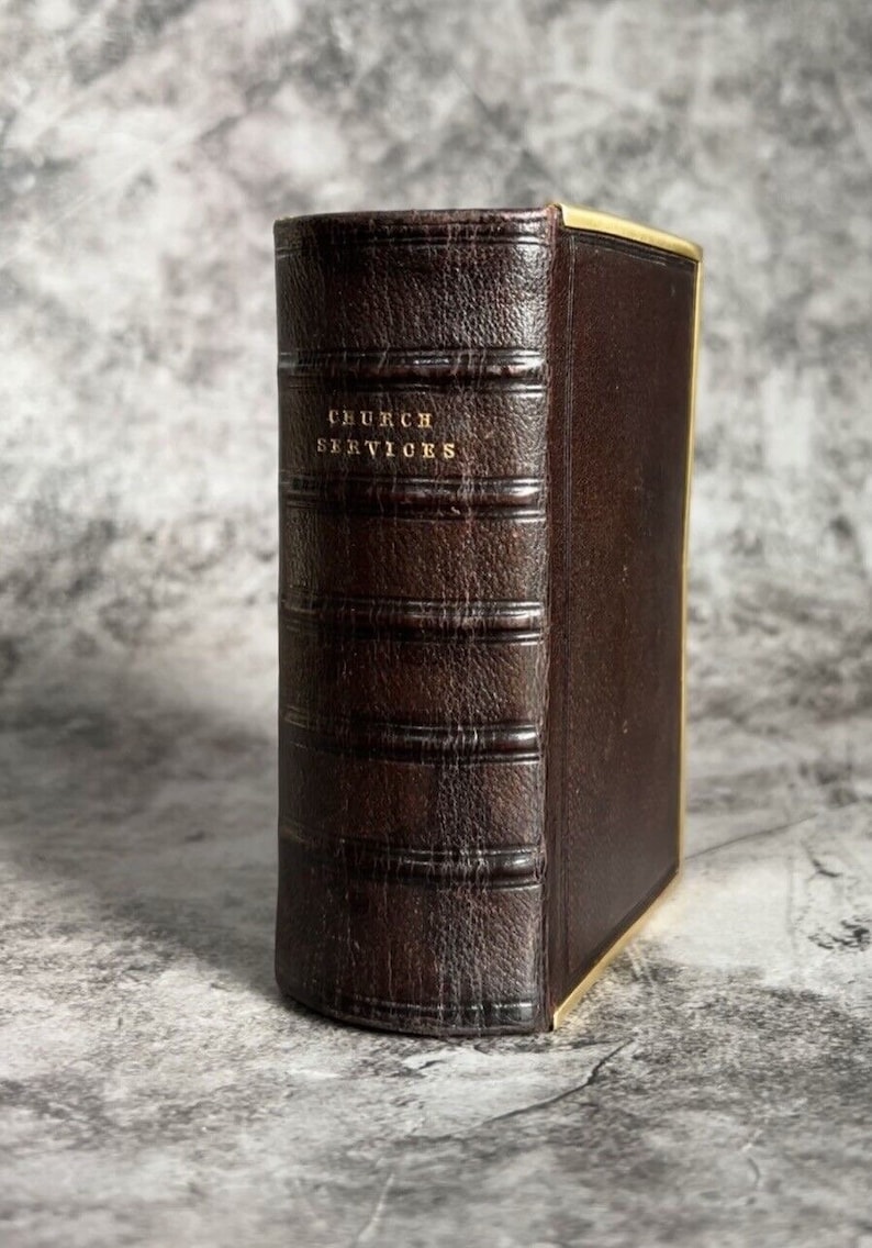 May include: A brown leather-bound book with gold lettering on the spine that reads "CHURCH SERVICES".