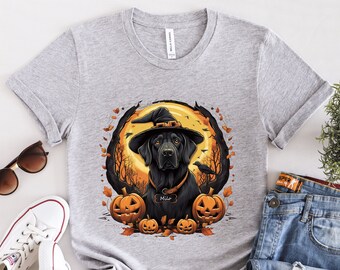 May include: A gray t-shirt with a black dog wearing a witch's hat and a collar with the name "Milo" on it. The dog is surrounded by pumpkins and fall leaves. The shirt is a great gift for dog lovers and Halloween fans.