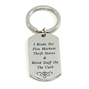 May include: Silver keychain with a tag that reads "I Brake For Flea Markets Thrift Stores & Weird Stuff On The Curb".