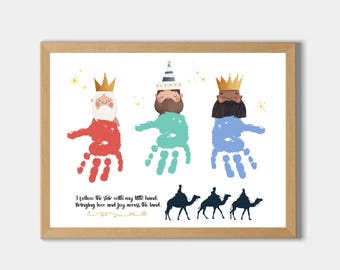 May include: A framed print with three handprint figures in red, teal, and blue, each wearing a crown. Silhouettes of camels and riders are below. The text reads, "I follow the star with my little hand. Bringing love and joy across the land."