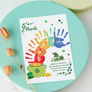 May include: A printable St. Patrick's Day craft for kids. The design features a rainbow made of handprints, a pot of gold, and a leprechaun. The text reads "In March, on St. Patrick's Day so green, Leprechauns play, a lively scene. Clovers dance, luck fills the air, Irish spirit, joy to share."