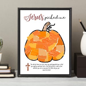 K&ouml;nnte beinhalten: Gerahmter Kunstdruck mit einem K&uuml;rbismotiv aus orangefarbenen und gelben Papierst&uuml;cken. Die Worte "Jesus picked me" sind in einer dekorativen Schriftart &uuml;ber dem K&uuml;rbis geschrieben. Darunter steht ein Bibelvers.