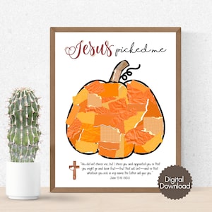 K&ouml;nnte beinhalten: Gerahmter Druck mit einem K&uuml;rbismotiv aus orangefarbenen Papierst&uuml;cken. Der Text "Jesus picked me" steht &uuml;ber dem K&uuml;rbis. Darunter ein Bibelvers und ein Kreuz. Links ein Kaktus in einem wei&szlig;en Topf.