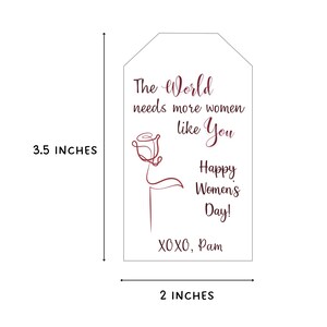 May include: A white gift tag with a burgundy rose design and the text "The World needs more women like You Happy Women's Day! XOXO, Pam". The tag is 3.5 inches tall and 2 inches wide.