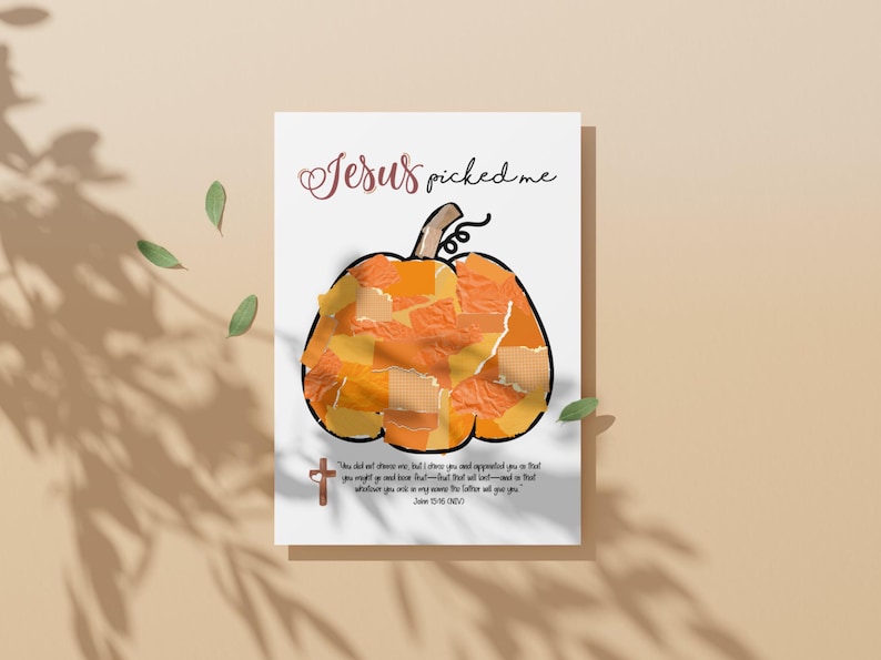 K&ouml;nnte beinhalten: Eine wei&szlig;e Karte mit einer K&uuml;rbisillustration aus orangefarbenen und gelben Papierst&uuml;cken. Der Text "Jesus picked me" ist in einer Schreibschrift geschrieben. Ein kleines Kreuz und ein Bibelvers sind ebenfalls vorhanden.