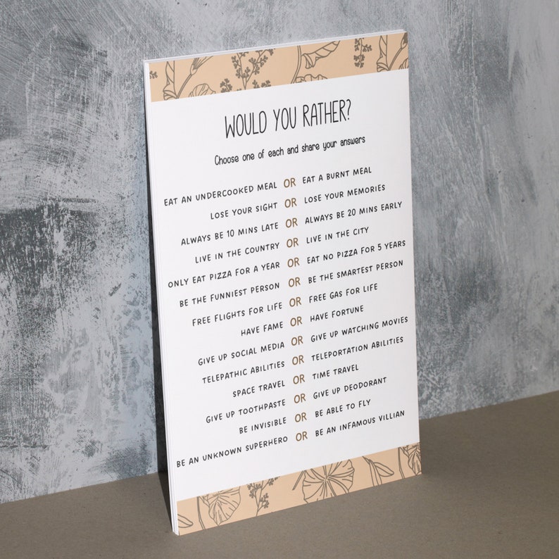 Puede incluir: Una tarjeta de juego imprimible "Would You Rather?" con un fondo marr&oacute;n claro y un borde floral. La tarjeta presenta una lista de 16 preguntas, cada una con dos opciones, impresas en una fuente dorada.