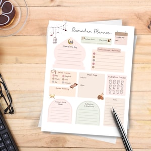 May include: A printable Ramadan planner with sections for daily goals, prayer tracking, meal prep, hydration, Quran reading, reflection, and gratitude. The planner features a pink and brown color scheme with illustrations of a mosque, crescent moons, and other Islamic symbols.