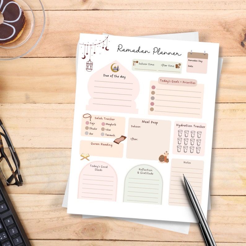 May include: A printable Ramadan planner with sections for daily goals, prayer tracking, meal prep, hydration, Quran reading, reflection, and gratitude. The planner features a pink and brown color scheme with illustrations of a mosque, crescent moons, and other Islamic symbols.