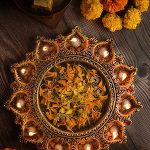 The 11 diya thali is a stunning decorative piece, perfect for festivals and rituals ,it makes a thoughtful gift radiating warmth decor.