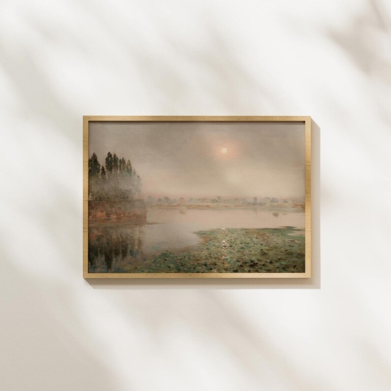 May include: A framed painting of a misty landscape with a lake and trees in the foreground. The sky is a pale blue with a faint sun shining through the clouds.